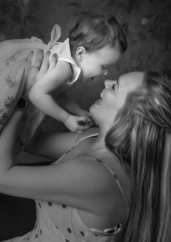 mother holding baby in the air and having a tender moment.